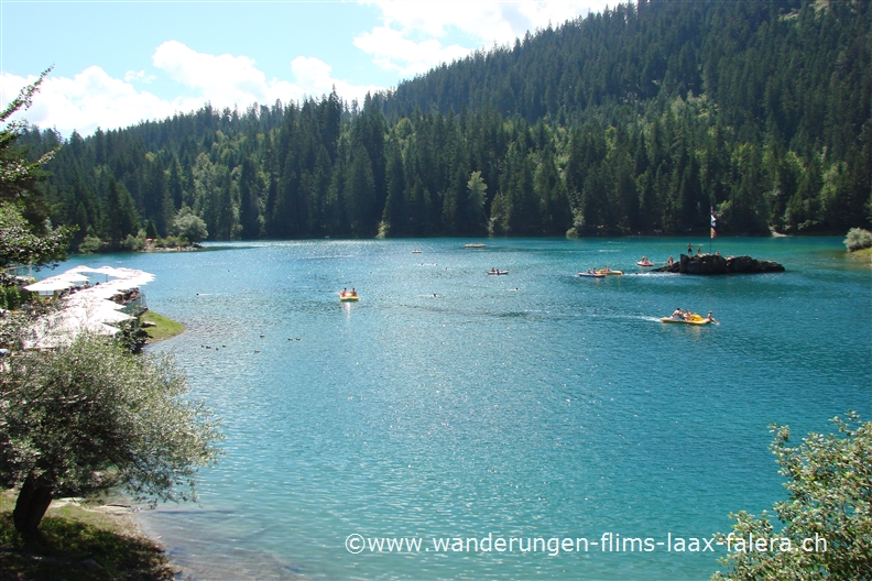 Der Caumasee mit dem Restaurant der kleinen Pirateninsel und einigen Booten
