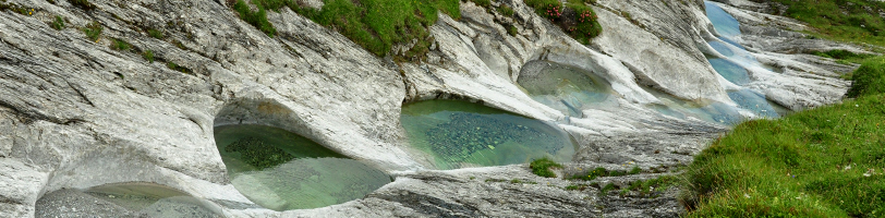 Gletschermühlen auf der Alp Mora (Trin) mittürkisklarem Wasser