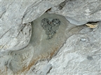 Ein aus Steinen geformtes Herz in einer Gletschermühle