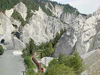 Roter Eisenbahnzug in der Rheinschlucht kurz vor Versam-Safien